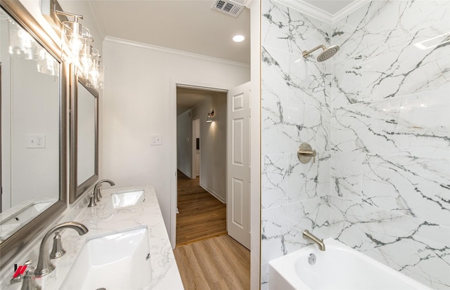 bathroom featuring crown molding, hardwood / wood-style floors, vanity, and tiled shower / bath