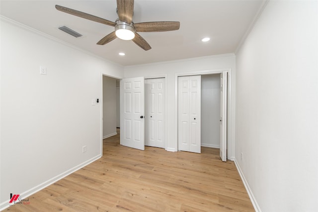 unfurnished bedroom with ceiling fan, light hardwood / wood-style flooring, two closets, and ornamental molding