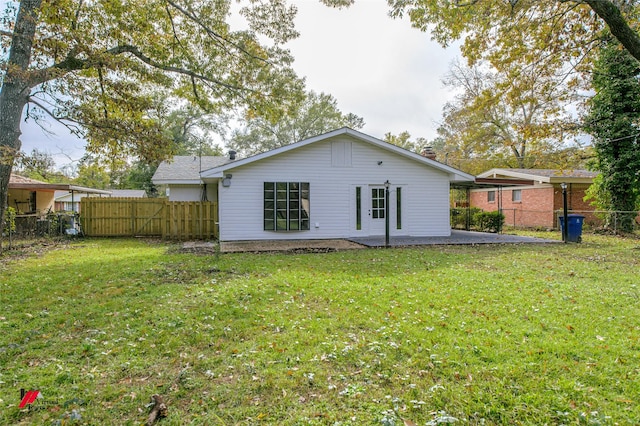 back of property with a yard and a patio