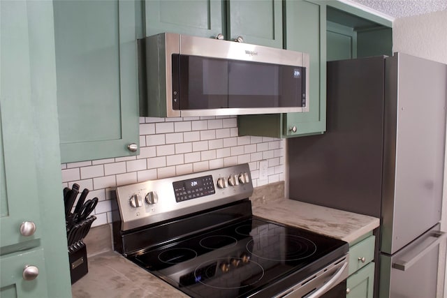 kitchen with decorative backsplash, appliances with stainless steel finishes, and green cabinets