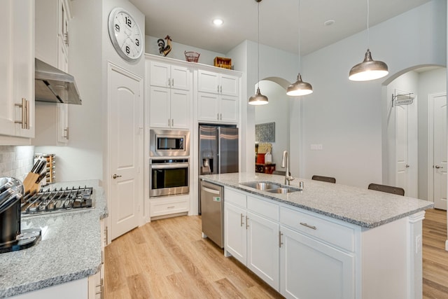 kitchen featuring sink, stainless steel appliances, pendant lighting, a center island with sink, and white cabinets