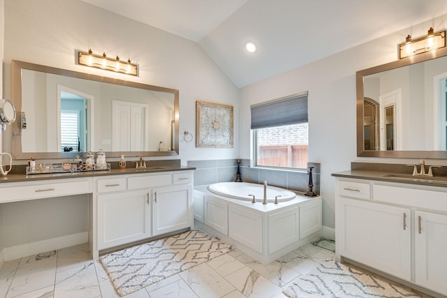 bathroom featuring vanity, lofted ceiling, and a tub to relax in