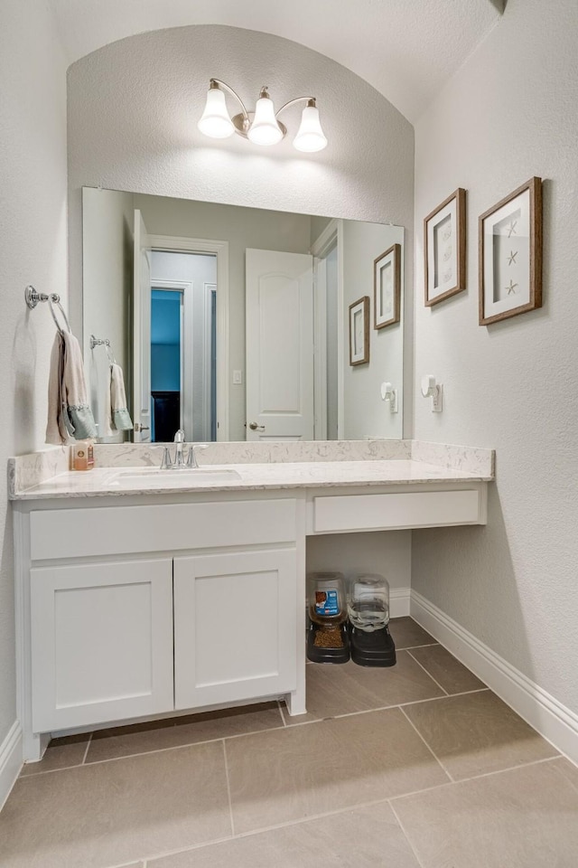 bathroom featuring tile patterned flooring, vanity, and lofted ceiling