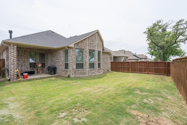 rear view of property featuring a patio area and a yard