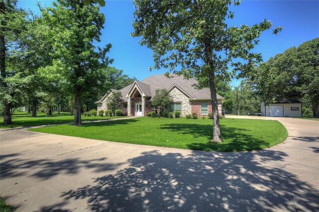 view of front of property featuring an outbuilding, a garage, and a front yard