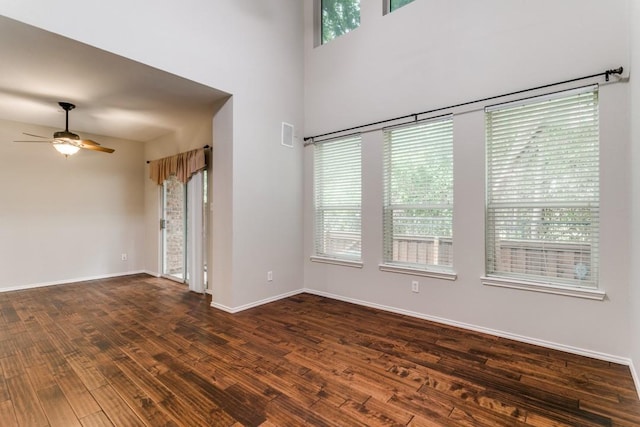 spare room with dark hardwood / wood-style floors, a healthy amount of sunlight, and ceiling fan