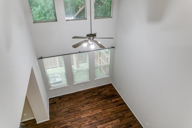 unfurnished living room featuring dark hardwood / wood-style flooring and ceiling fan