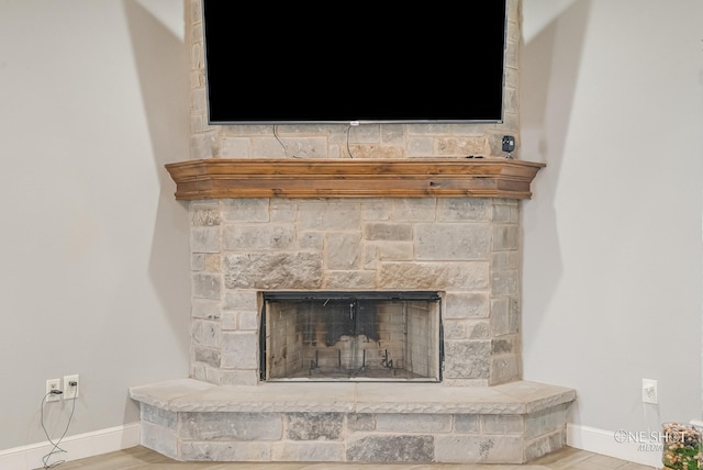 interior details featuring hardwood / wood-style flooring and a stone fireplace