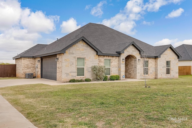 french country inspired facade featuring a garage and a front yard