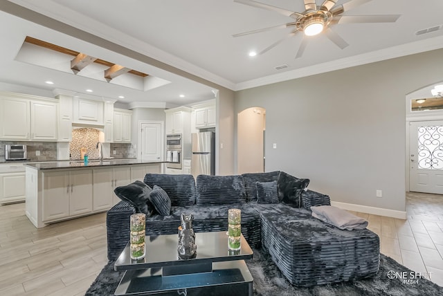 living room featuring crown molding, ceiling fan, and sink