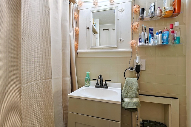 bathroom featuring backsplash, vanity, and tile walls