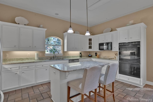 kitchen featuring sink, light stone counters, black appliances, a kitchen island, and white cabinets