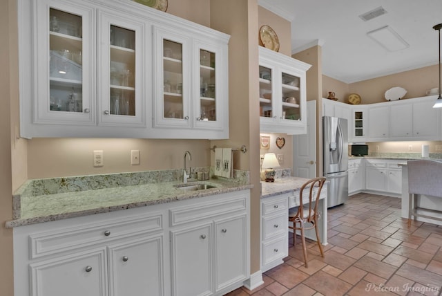 9622 Norris Ferry Rd, Shreveport, LA 71106 - kitchen featuring stainless steel refrigerator with ice dispenser, white cabinetry, light stone countertops, glass insert cabinets, and crown molding