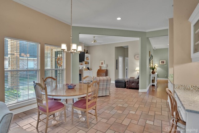 dining area featuring ceiling fan with notable chandelier and crown molding