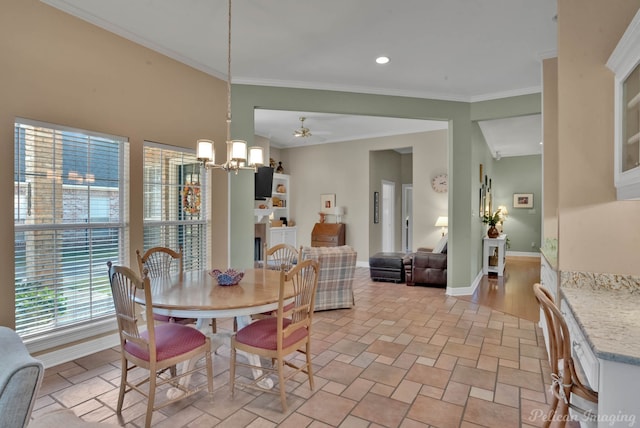 dining room featuring crown molding and ceiling fan with notable chandelier