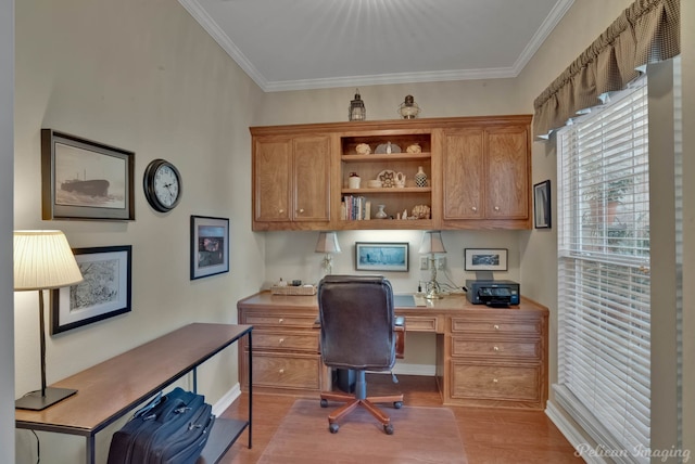 home office featuring built in desk, light wood-type flooring, and ornamental molding