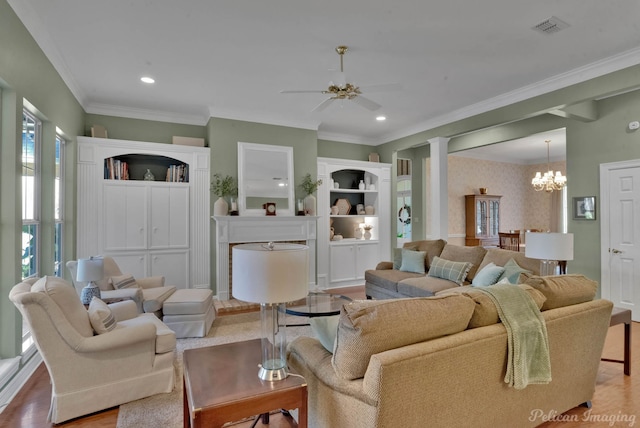 living room with crown molding, a chandelier, and light wood-type flooring