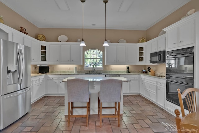 kitchen with decorative light fixtures, white cabinetry, sink, a center island, and black appliances