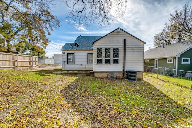 back of house with a lawn and central AC