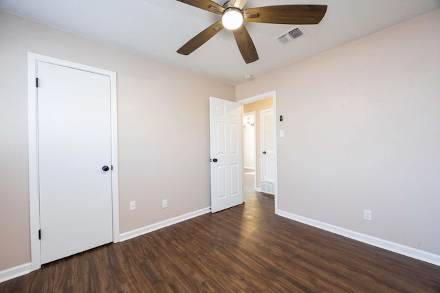 unfurnished bedroom with ceiling fan and dark wood-type flooring