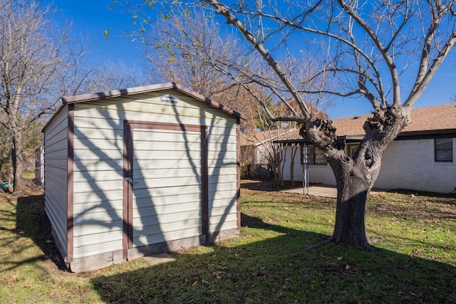 view of side of home featuring a storage unit and a lawn