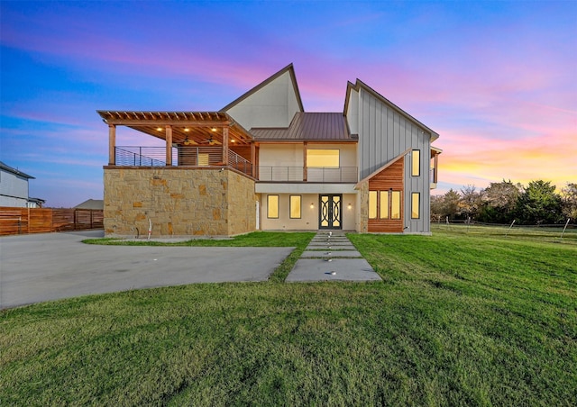 view of front of property featuring a yard, french doors, and a balcony