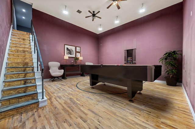 interior space featuring ceiling fan, light wood-type flooring, and a high ceiling