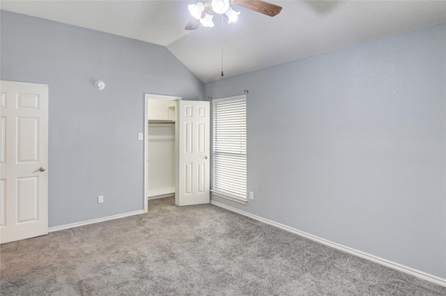 unfurnished bedroom featuring ceiling fan, a spacious closet, lofted ceiling, light carpet, and a closet