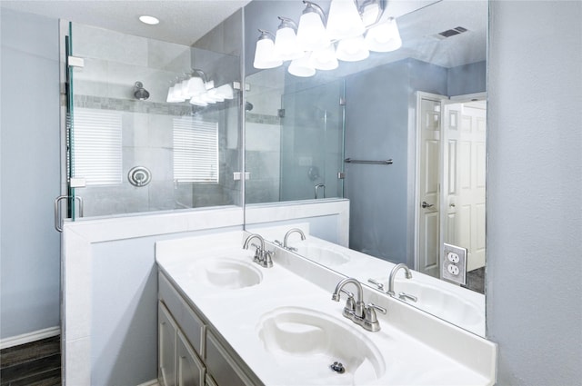 bathroom featuring a textured ceiling, vanity, and walk in shower