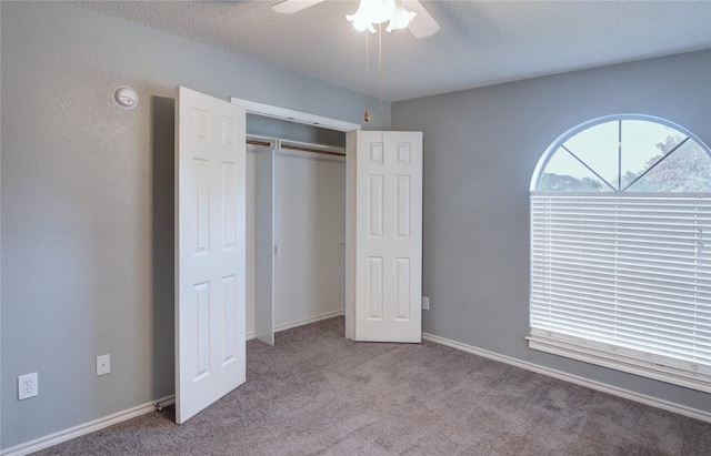 unfurnished bedroom featuring ceiling fan, a closet, and light carpet