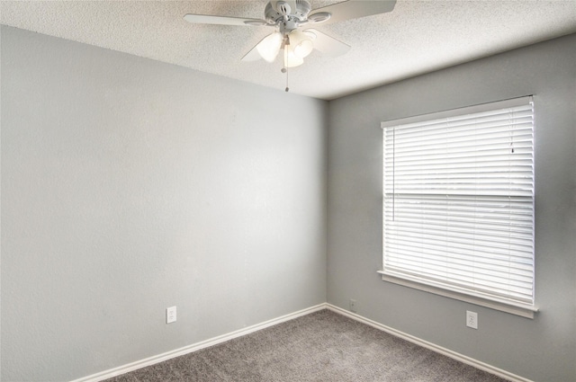 carpeted spare room with ceiling fan and a textured ceiling