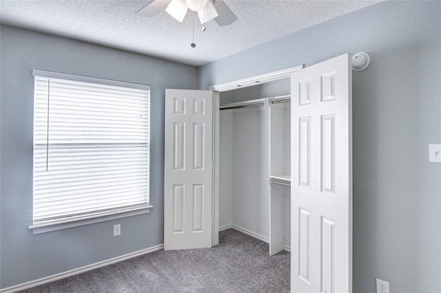 unfurnished bedroom with ceiling fan, a closet, light carpet, and a textured ceiling