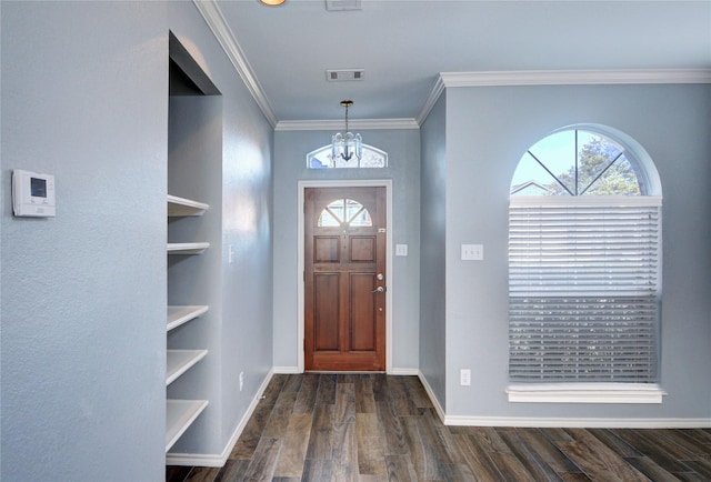 foyer entrance with dark hardwood / wood-style floors, ornamental molding, and a notable chandelier