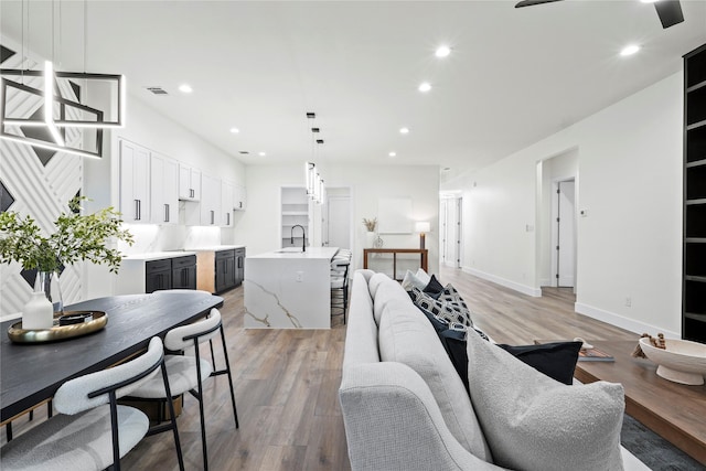 living room featuring sink and light hardwood / wood-style floors