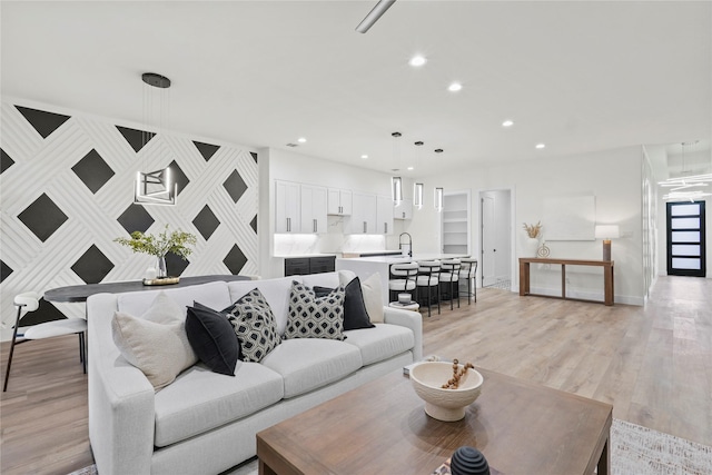 living room with light wood-type flooring and sink