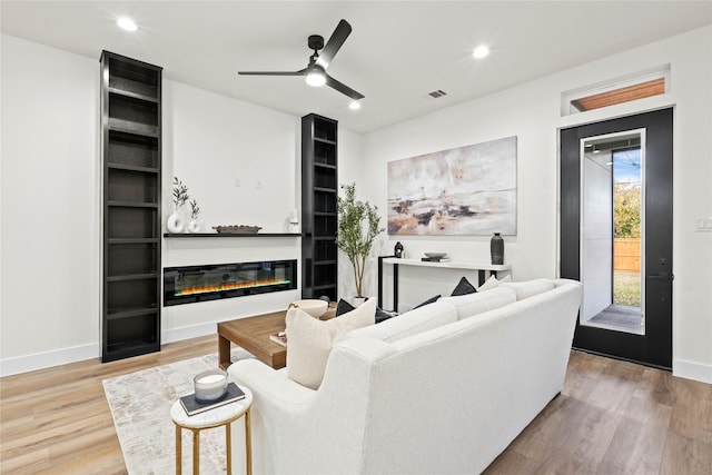 living room featuring ceiling fan and wood-type flooring