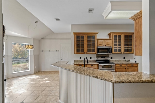 kitchen featuring light stone counters, stainless steel appliances, light tile patterned flooring, and vaulted ceiling