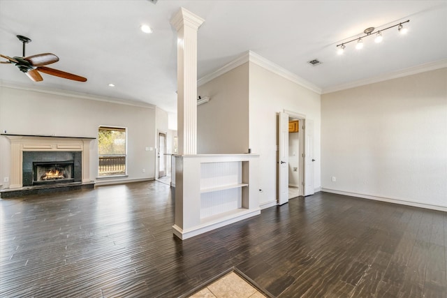 unfurnished living room featuring dark hardwood / wood-style flooring, ornate columns, ceiling fan, and ornamental molding