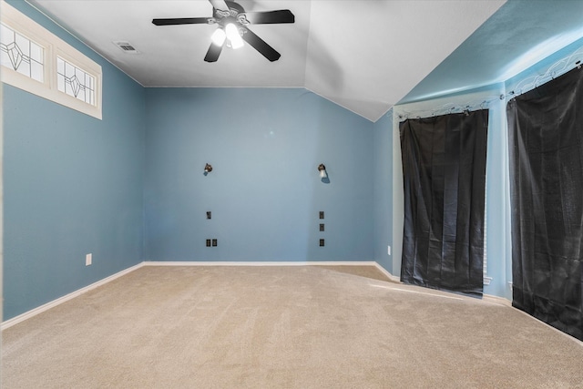 carpeted empty room with vaulted ceiling and ceiling fan