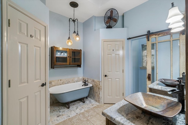 bathroom with a bath, sink, tile walls, and tile patterned floors