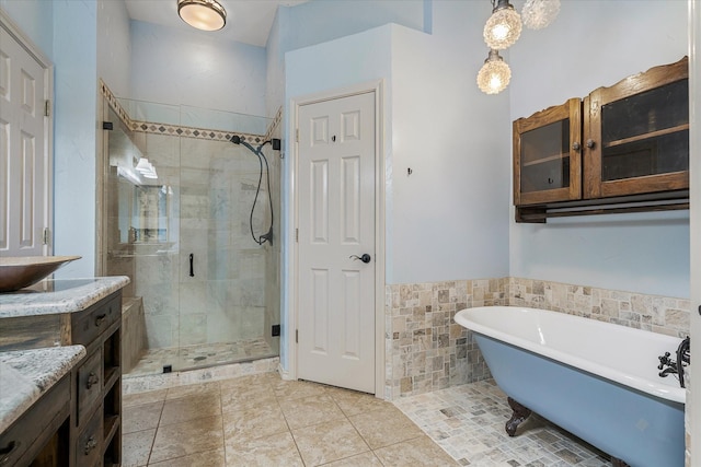 bathroom featuring vanity, plus walk in shower, tile patterned flooring, and tile walls