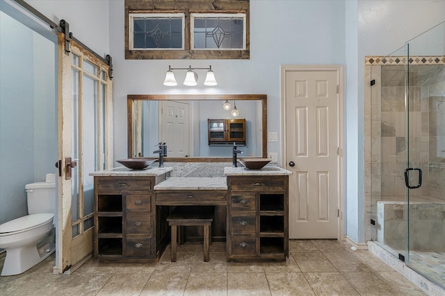 bathroom with vanity, toilet, a shower with shower door, and tile patterned flooring