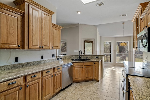 kitchen featuring a healthy amount of sunlight, stainless steel appliances, light stone countertops, and sink