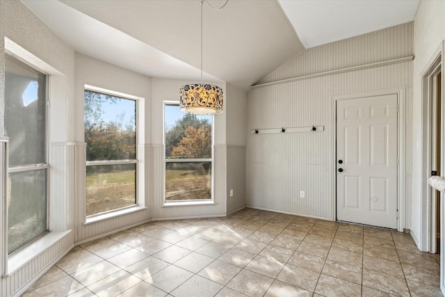 unfurnished dining area featuring light tile patterned flooring and lofted ceiling