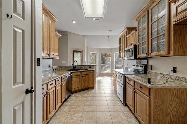 kitchen featuring sink, hanging light fixtures, light tile patterned floors, appliances with stainless steel finishes, and light stone countertops