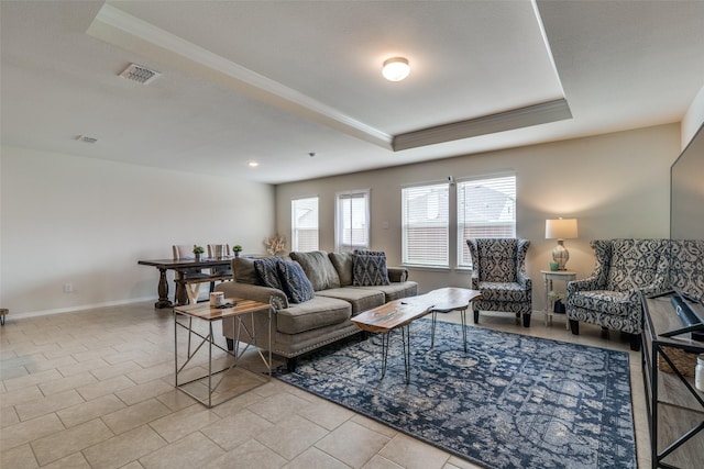 living room with crown molding, a tray ceiling, and light tile patterned floors