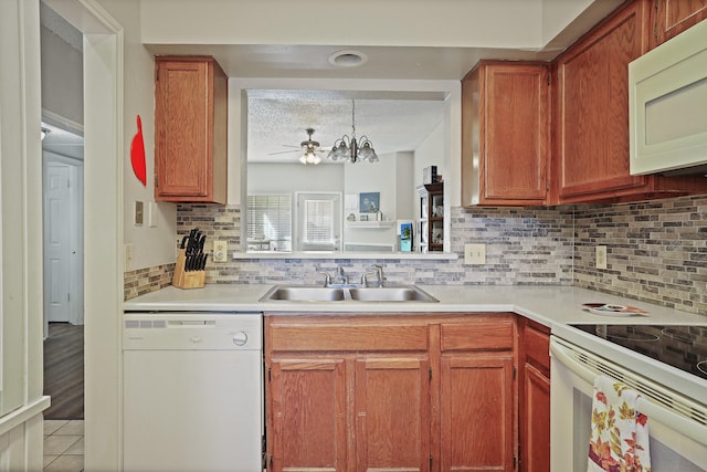 kitchen with decorative backsplash, a textured ceiling, white appliances, and sink