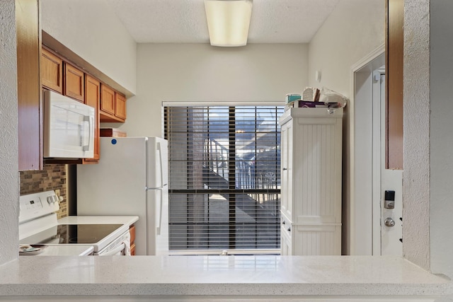 9601 Forest Ln Unit 412, Dallas, TX 75243 - kitchen featuring white appliances, brown cabinetry, decorative backsplash, and light stone counters