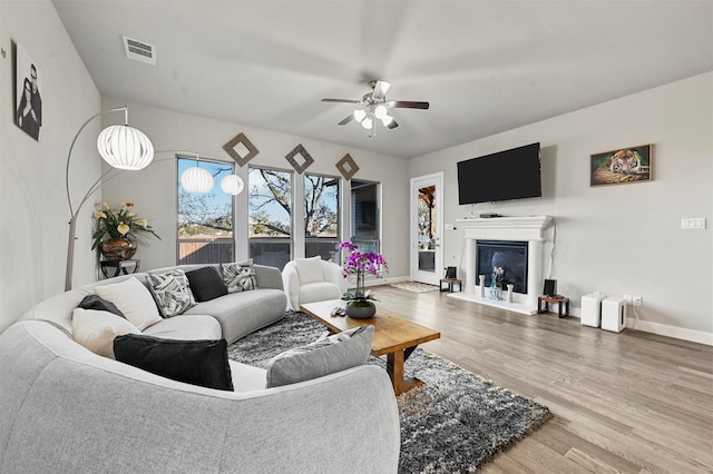 living room with ceiling fan and hardwood / wood-style flooring