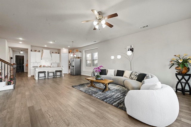 living room with ceiling fan and light hardwood / wood-style flooring